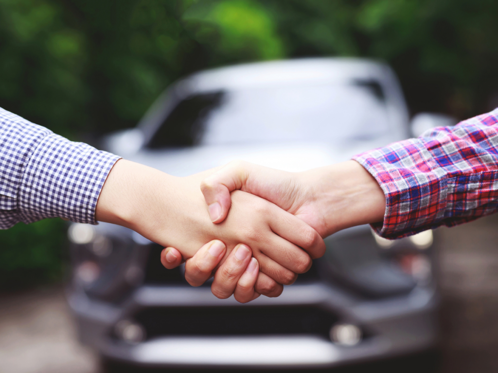 car owner and seller handshaking